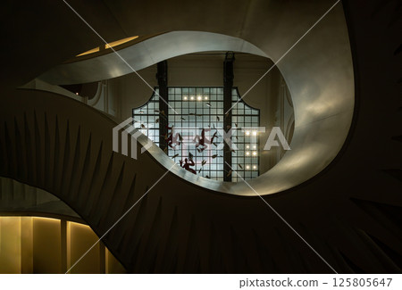 Looking up of The grand helical staircase featuring graceful curves and intricate design with glass ceiling in the background. Looking up of The grand helical staircase featuring graceful curves and intricate design with glass ceiling in the background. 125805647