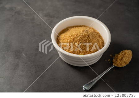 Light brown granulated sugar in a bowl. Copy space 125805753
