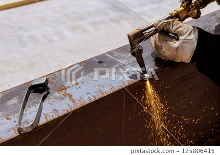 Welded metal cutting is being formed with sparks flying in industrial area location under works day 125806415