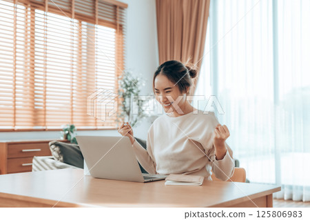 Funny euphoric young asian woman celebrating winning Funny euphoric young asian woman celebrating winning 125806983