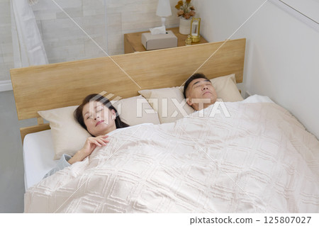 Couple sleeping in a double bed in the morning 125807027