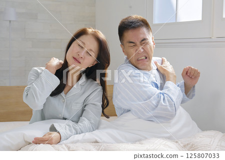 A couple waking up in bed, fatigue 125807033