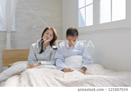A couple waking up in bed, fatigue 125807034