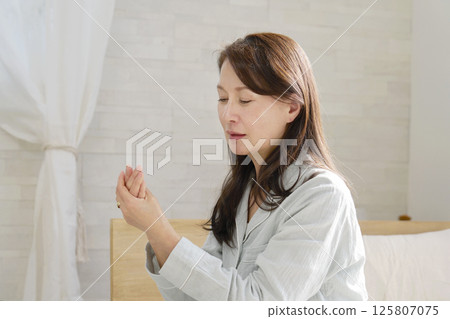 中年婦女穿著睡衣，患有風濕病，手冷 125807075