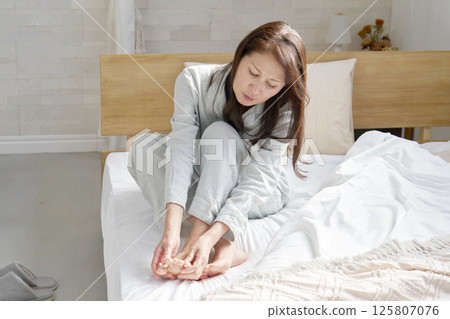 中年婦女穿著睡衣，患有風濕病和腳冷 125807076