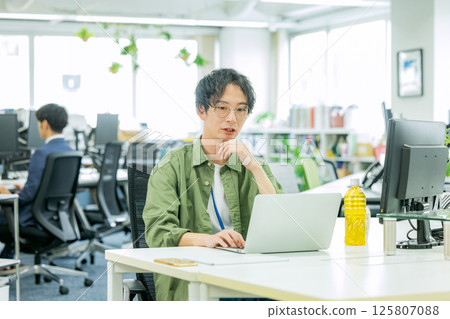 一名商人，在辦公室裡操作計算機 125807088