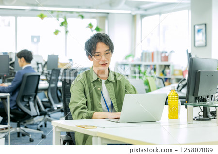 A businessman operating a personal computer in the office 125807089