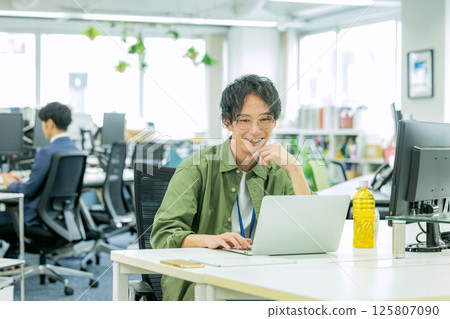 A businessman operating a personal computer in the office 125807090