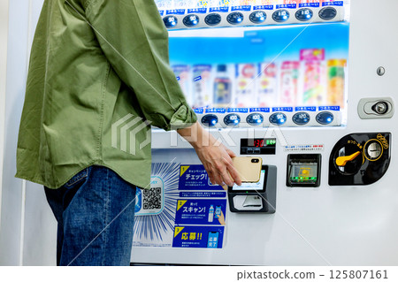 Man paying with smartphone at vending machine 125807161