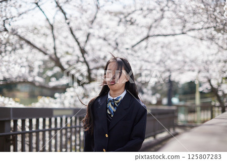 春天櫻花盛開的公園裡，國中女生開心玩耍 125807283