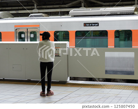A young foreign woman waiting for a train on the platform at Nagoya Station A young foreign woman waiting for a train on the platform at Nagoya Station 125807450