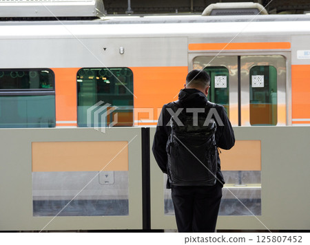 A middle-aged businessman waiting for a train on the platform at Nagoya Station 125807452