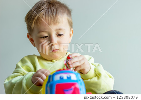 Little boy playing with toy car, child developing 125808079