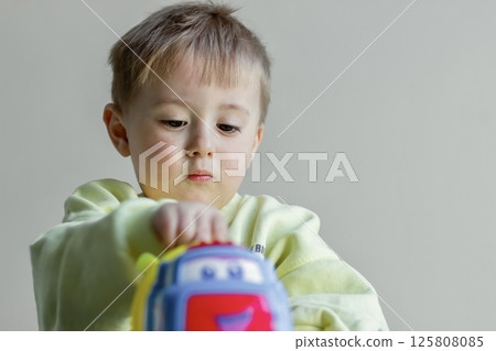 Little boy playing with toy car, child developing 125808085