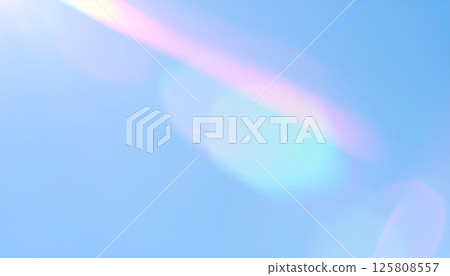 Radiant light streaks with rainbow highlights create surreal effect over soft blue gradient background, evoking sense of wonder and tranquility 125808557