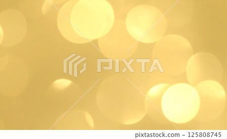 Golden shimmer creates gentle and festive atmosphere with soft bokeh circles and subtle light flares, evoking warmth and joy in any setting 125808745