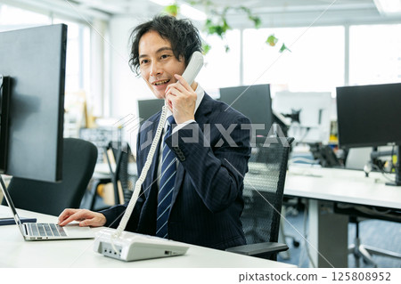 A young businessman calling in the office 125808952