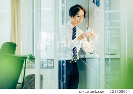 Businessman smoking an e-cigarette in the office 125808994