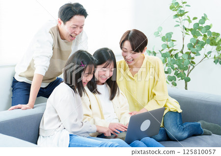 Families using personal computers in the living room Families using personal computers in the living room 125810057