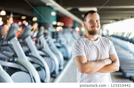 Young man posing by exercise bike 125810442