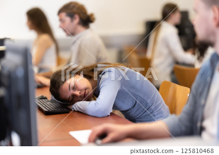 Young woman fell asleep at table in office Young woman fell asleep at table in office 125810468