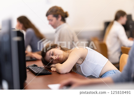 Young woman fell asleep at table in office 125810491