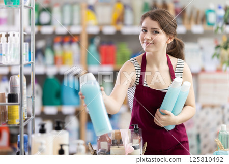Girl store employee working in sales area designs store window 125810492