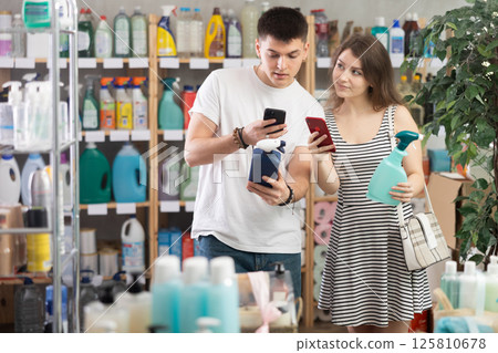 Couple buyer scans qr code on tile cleaner spay label 125810678