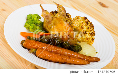 Broiled quail with baked vegetables 125810706