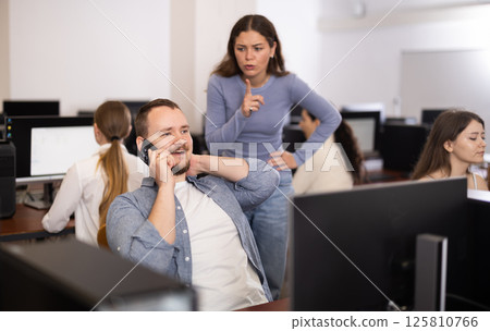 Female teacher makes remark to man student, asks to stop talking on phone during lesson Female teacher makes remark to man student, asks to stop talking on phone during lesson 125810766