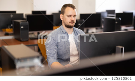 Young man working on computer in office 125810801
