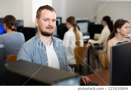 Young man working on computer in office Young man working on computer in office 125810904