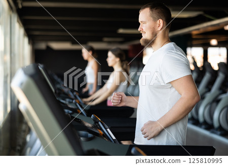 Young man exercising on treadmill in gym 125810995