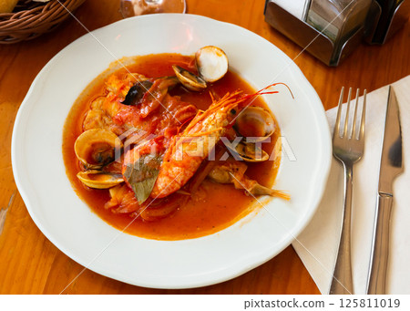 Monkfish tail in spicy sauce with shrimp and mussels 125811019