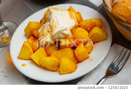 Spanish dish Patatas bravas with hot sauce 125811023