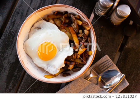 Fried potatoes with onion, mushrooms and sunny side up egg Fried potatoes with onion, mushrooms and sunny side up egg 125811027