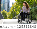 Young woman in a wheelchair on a city street 125811848