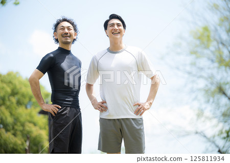 Two refreshing men playing sports under the blue sky looking at the camera Two refreshing men playing sports under the blue sky looking at the camera 125811934