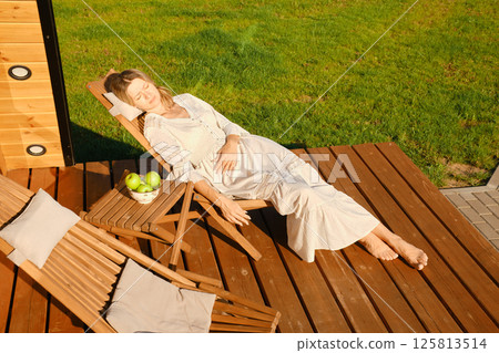 Overhead view of dreaming woman on terrace of country house 125813514