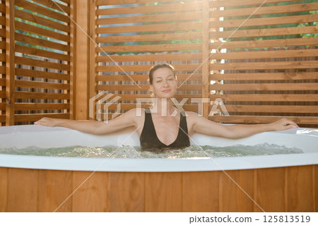 Mid adult woman bathing in hot tub Mid adult woman bathing in hot tub 125813519