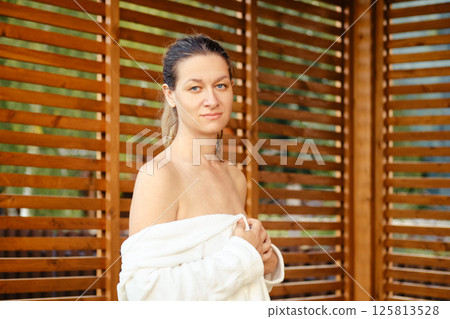 An image of a woman in a bathrobe with a calm expression An image of a woman in a bathrobe with a calm expression 125813528