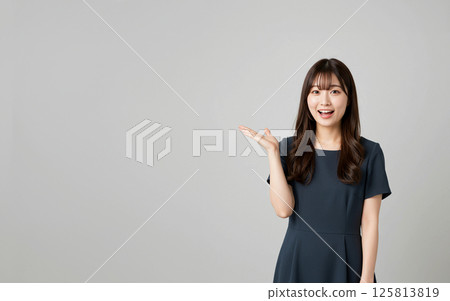 A Japanese woman explaining with a smile and gestures 125813819