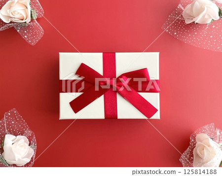 A gift box and a bouquet on a red background A gift box and a bouquet on a red background 125814188