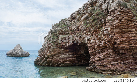 Beautiful rocks and bright turquoise water among layered rocks near Budva, Montenegro. Tropical summer landscape exotic beach on the Adriatic Sea. Vacation 125814519