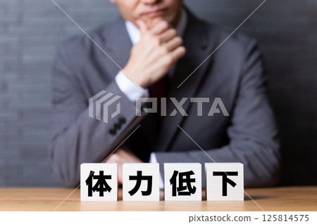 一位中年男性商人穿著西裝,擔心身體虛弱 一位中年男性商人穿著西裝,擔心身體虛弱 125814575