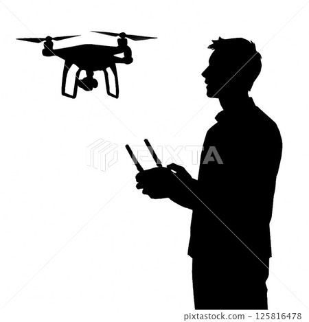 Silhouette of a man piloting a drone 125816478