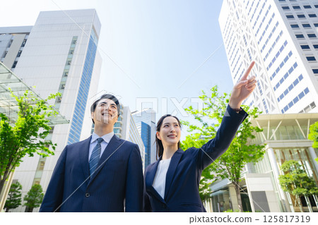 一群商務人士站在綠樹成蔭的城市的側面視圖 一群商務人士站在綠樹成蔭的城市的側面視圖 125817319