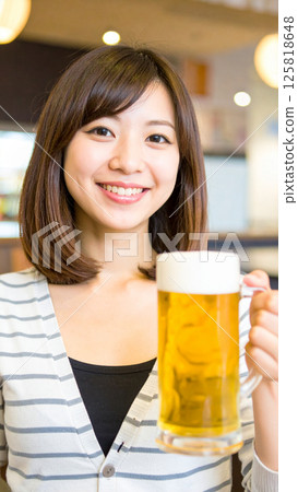 Smiling woman holding a beer (AI-generated image) 125818648