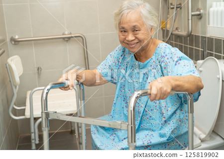 Asian elderly woman patient use walker and toilet bathroom handle security in nursing hospital. 125819902