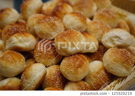 Pile of Golden Brown Sesame Seed Bread Rolls 125820219